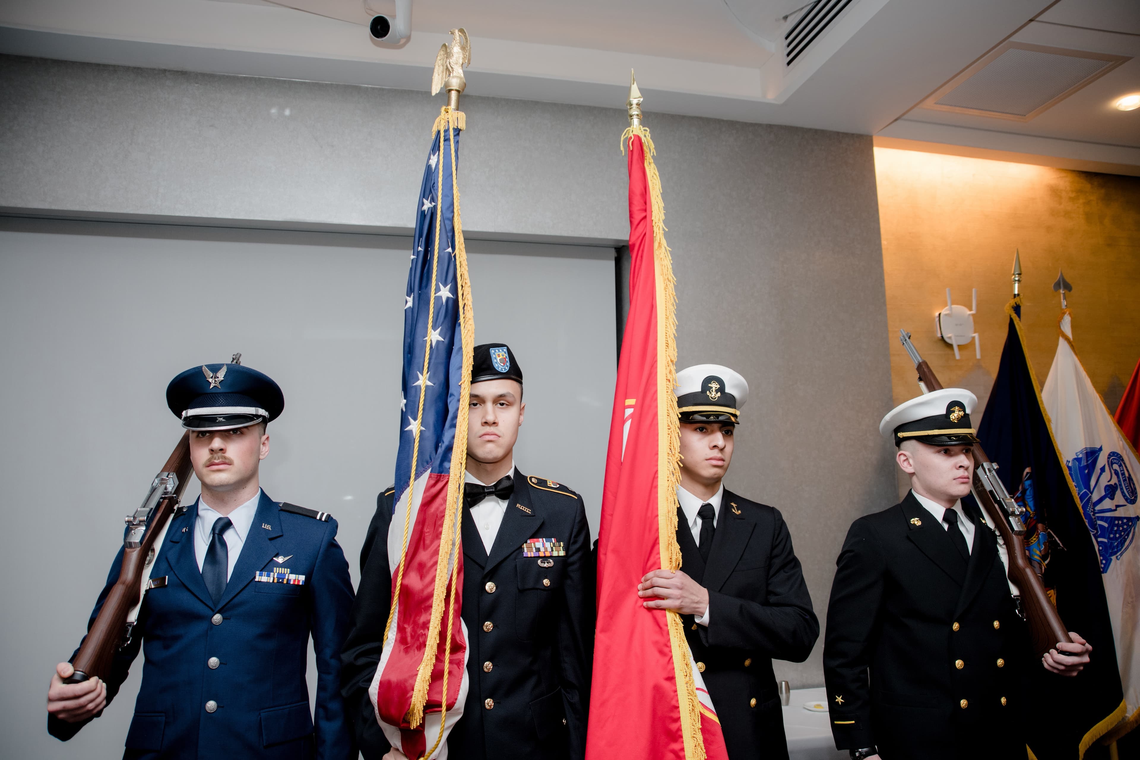 The Joint Service Color Guard posted with the national colors and service flags at a formal event.