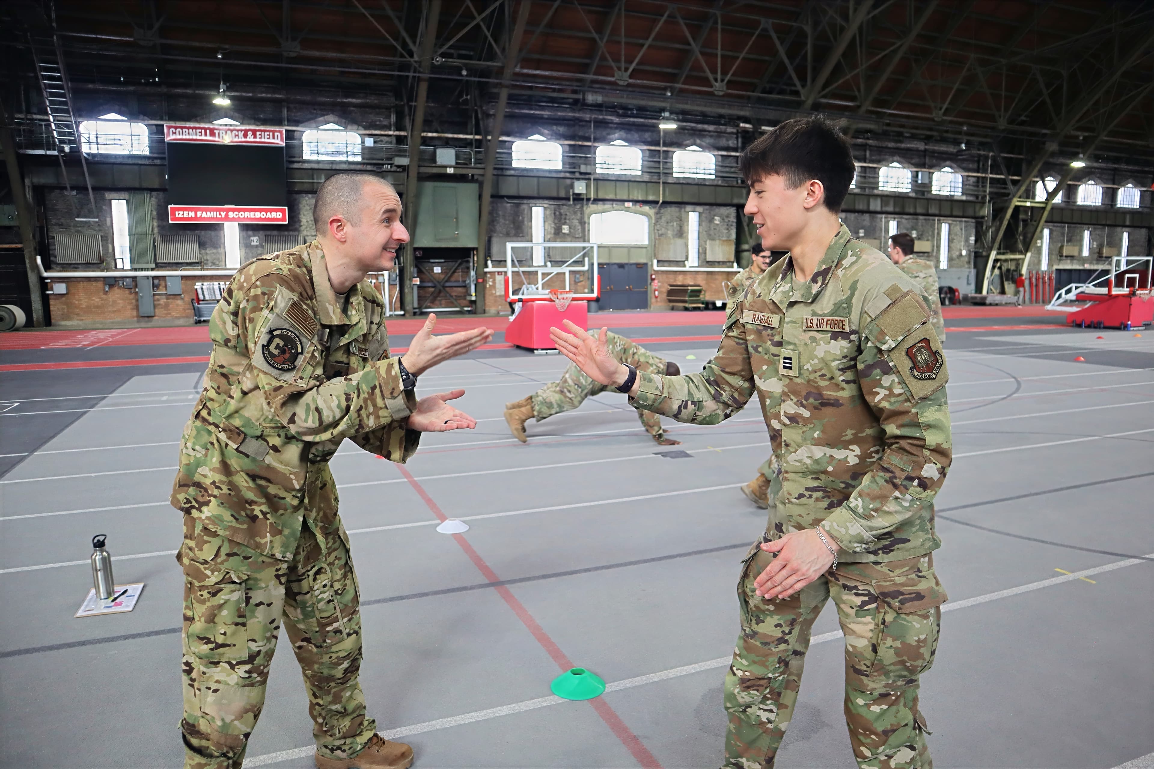A cadre member and a cadet share a lighthearted moment on the Barton Hall floor.