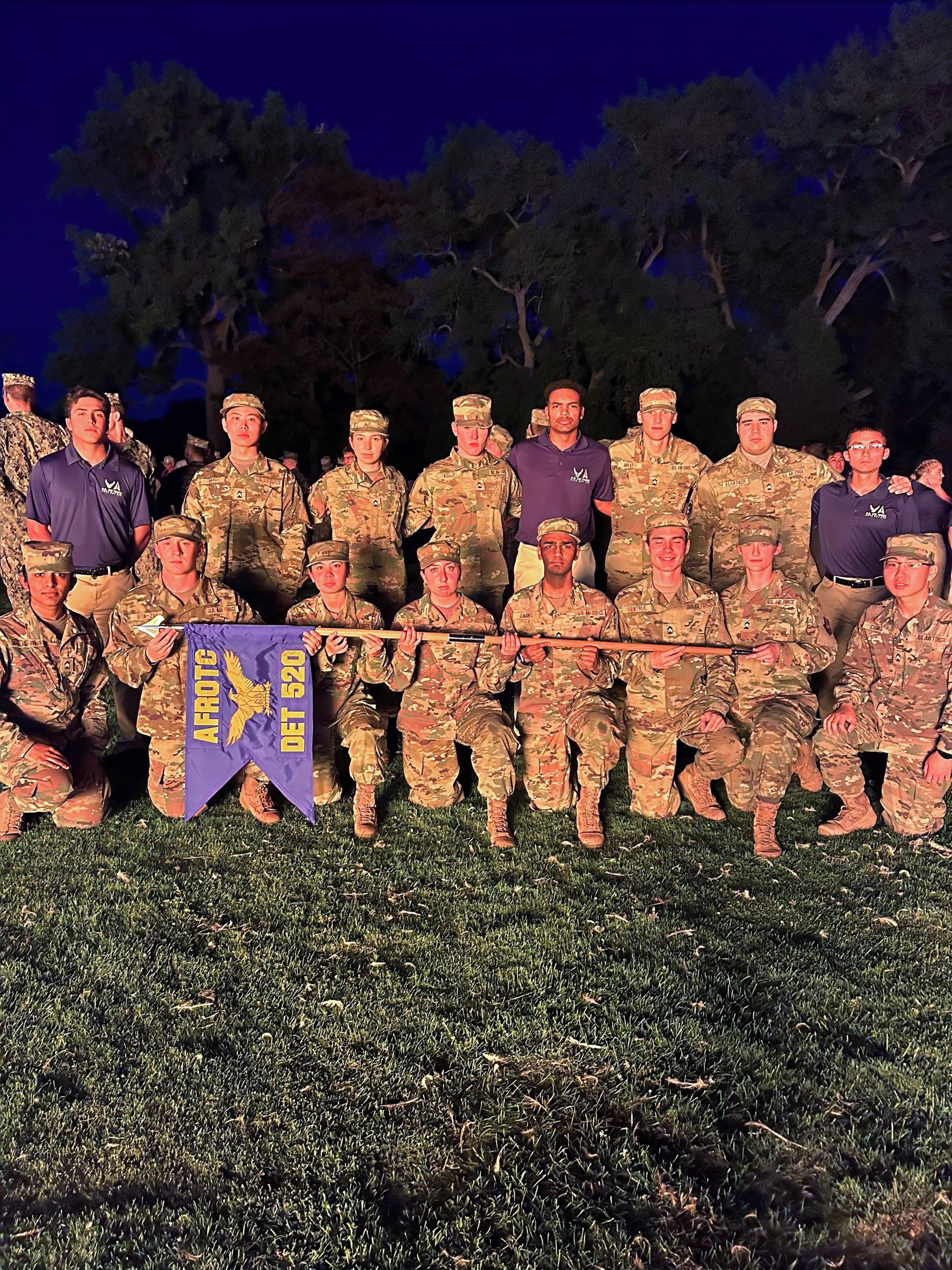 The detachment poses with its guidon at dusk at the Watchfire site.