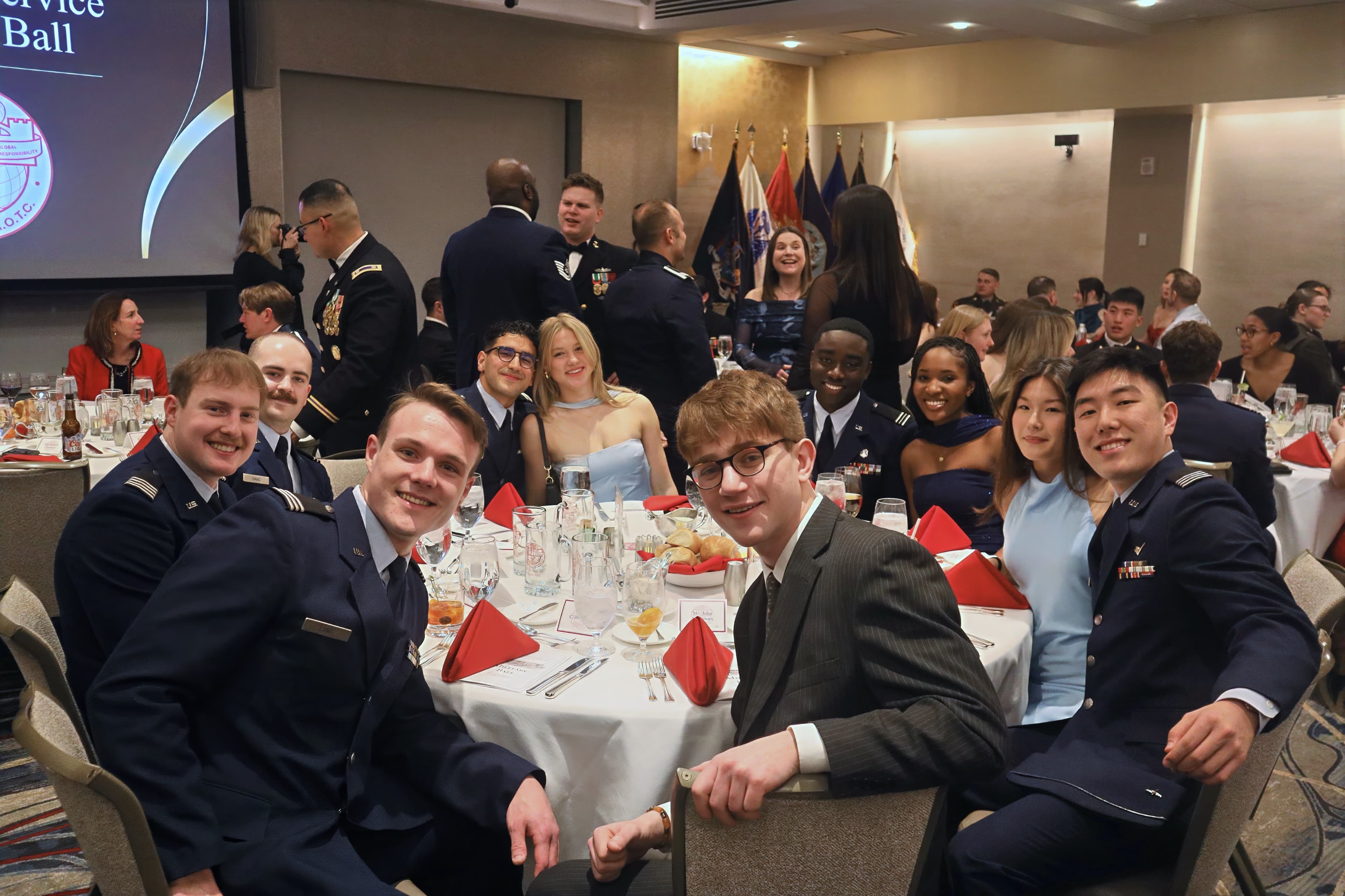Cadets and guests smile around a banquet table at the Military Ball.