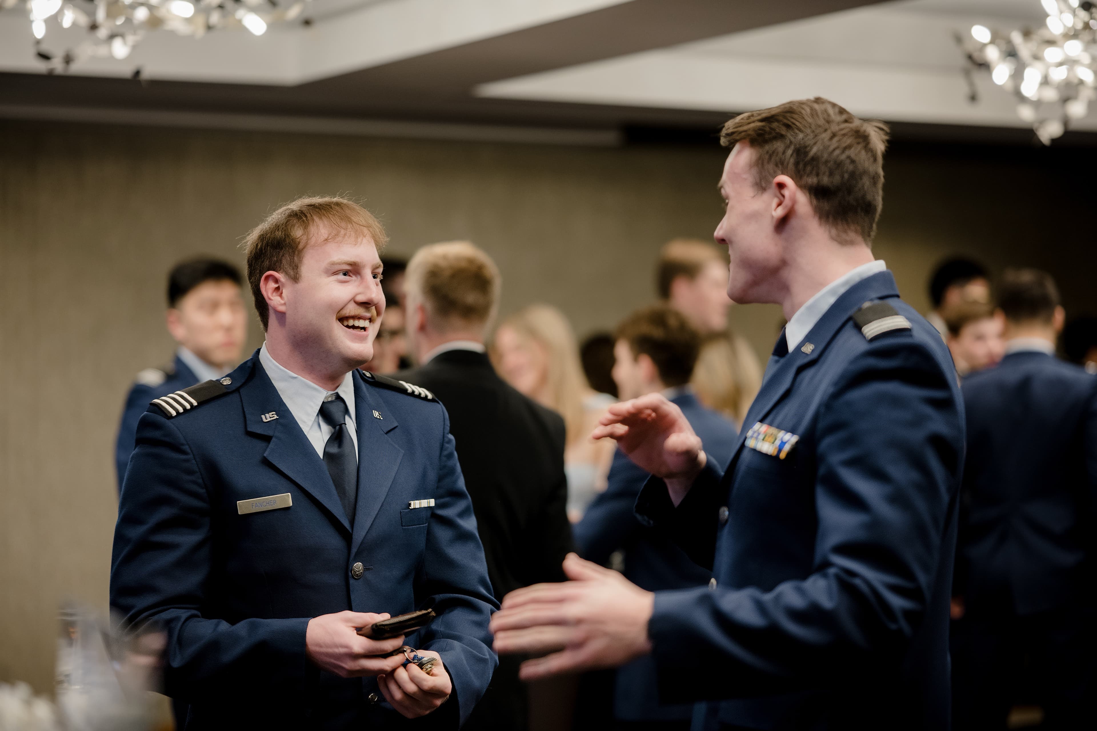 Two cadets in service dress share a laugh during the Military Ball.