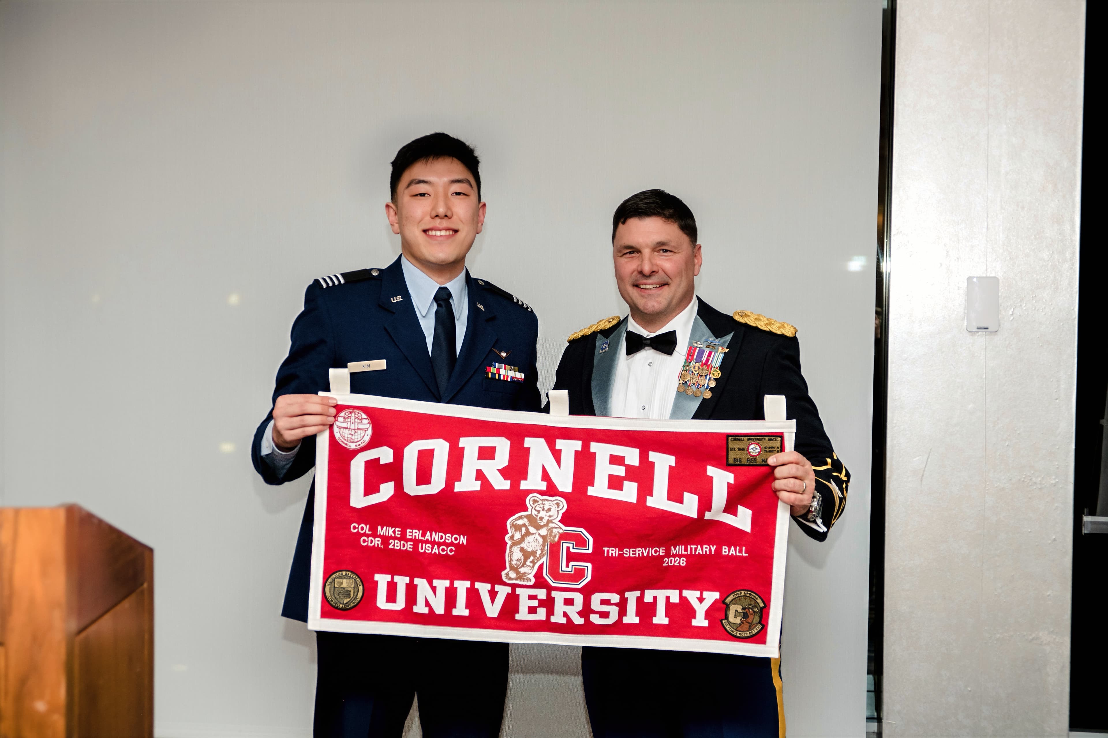 A cadet and the evening's guest of honor hold a Cornell University pennant at the Military Ball.