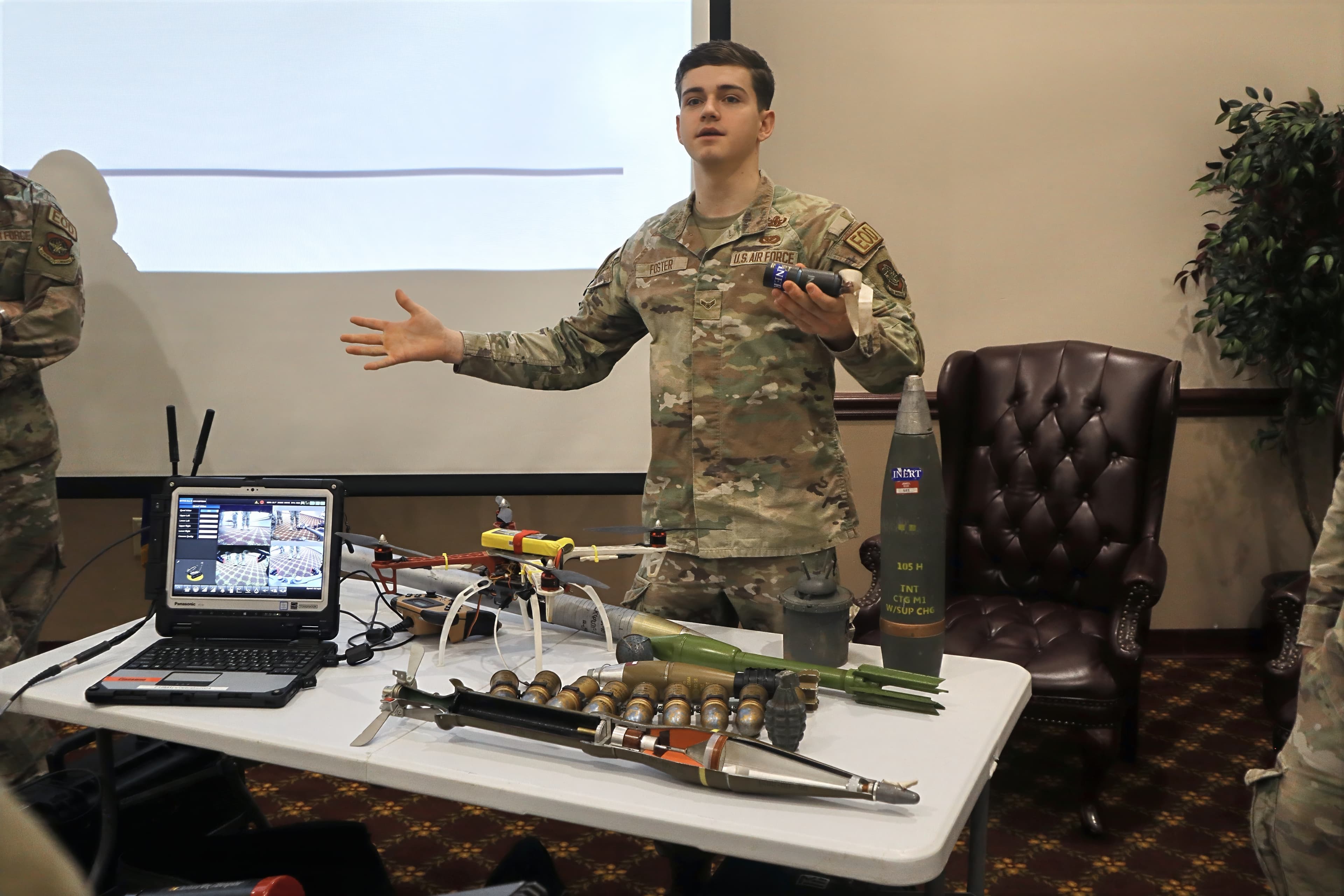 An Airman explains a table of inert training munitions to visiting cadets.