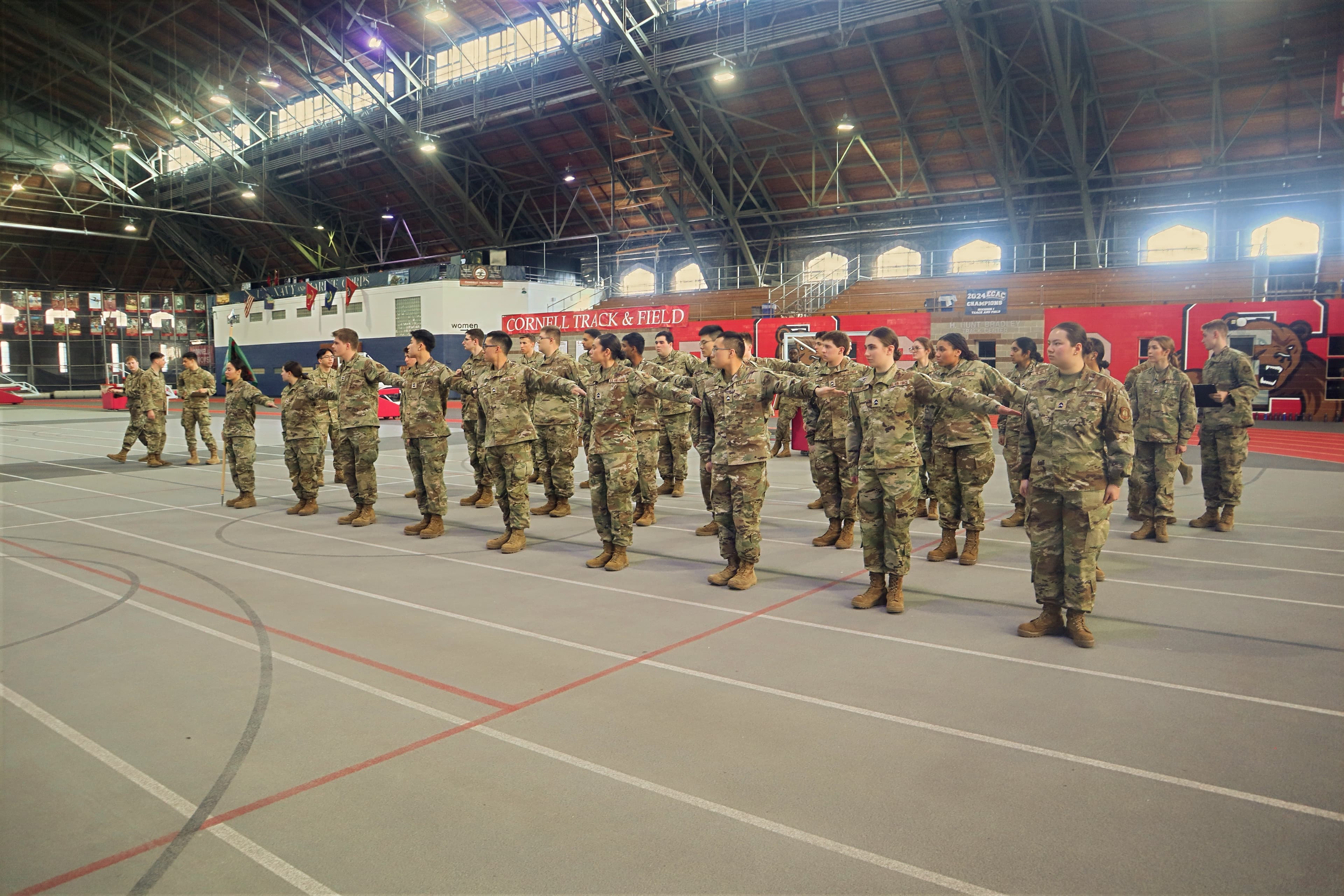 The full detachment formed up on the Barton Hall track during Leadership Laboratory, seen from the side beneath the arched trusses.