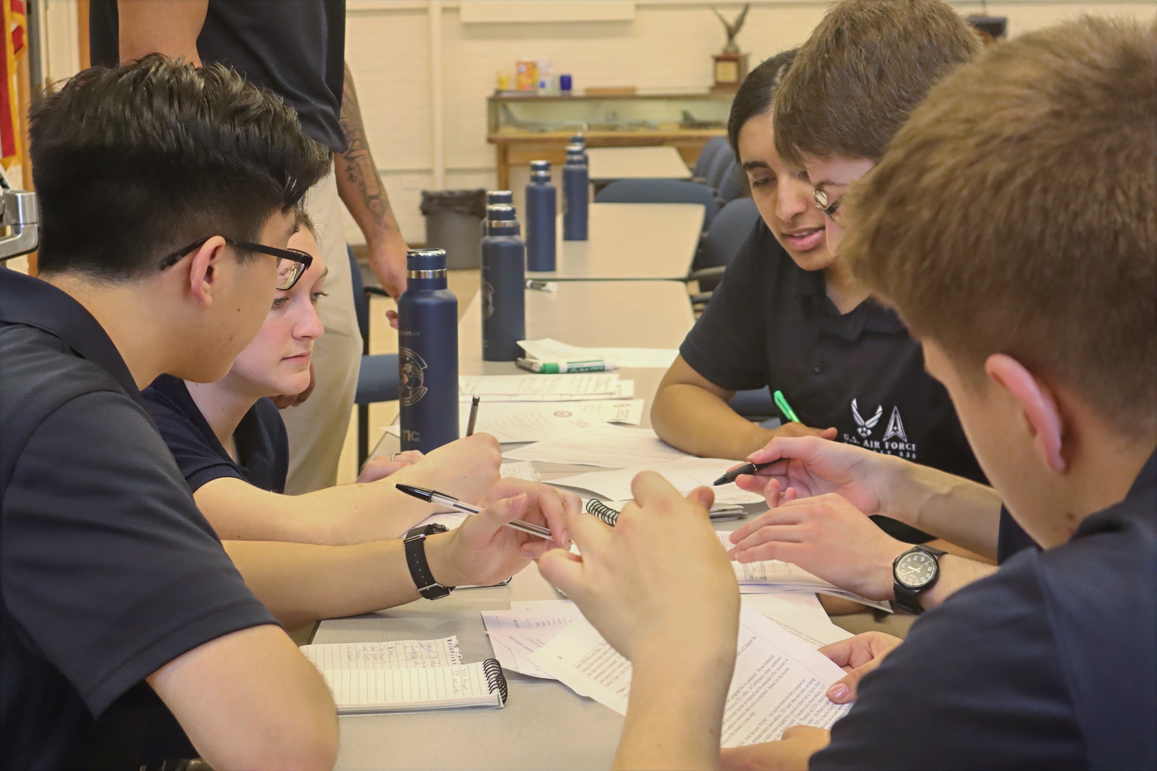 Cadets seated at a table working through planning papers during a leadership problem.