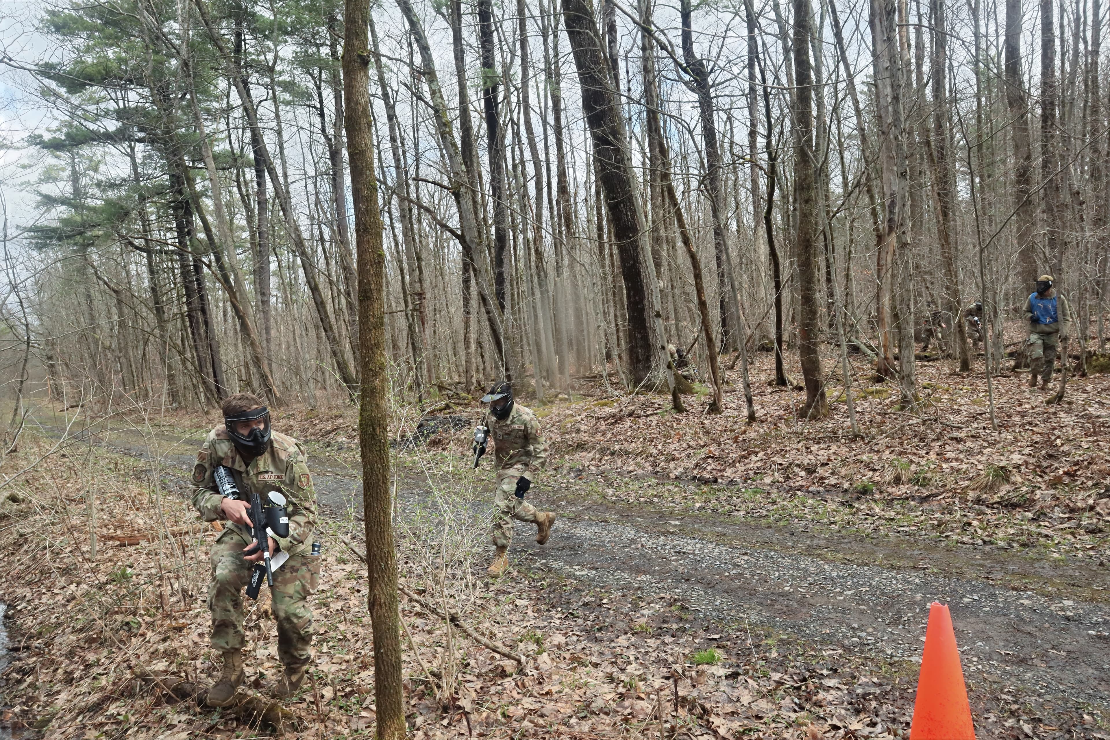 Two masked cadets stop on a gravel road to check a map during the exercise.