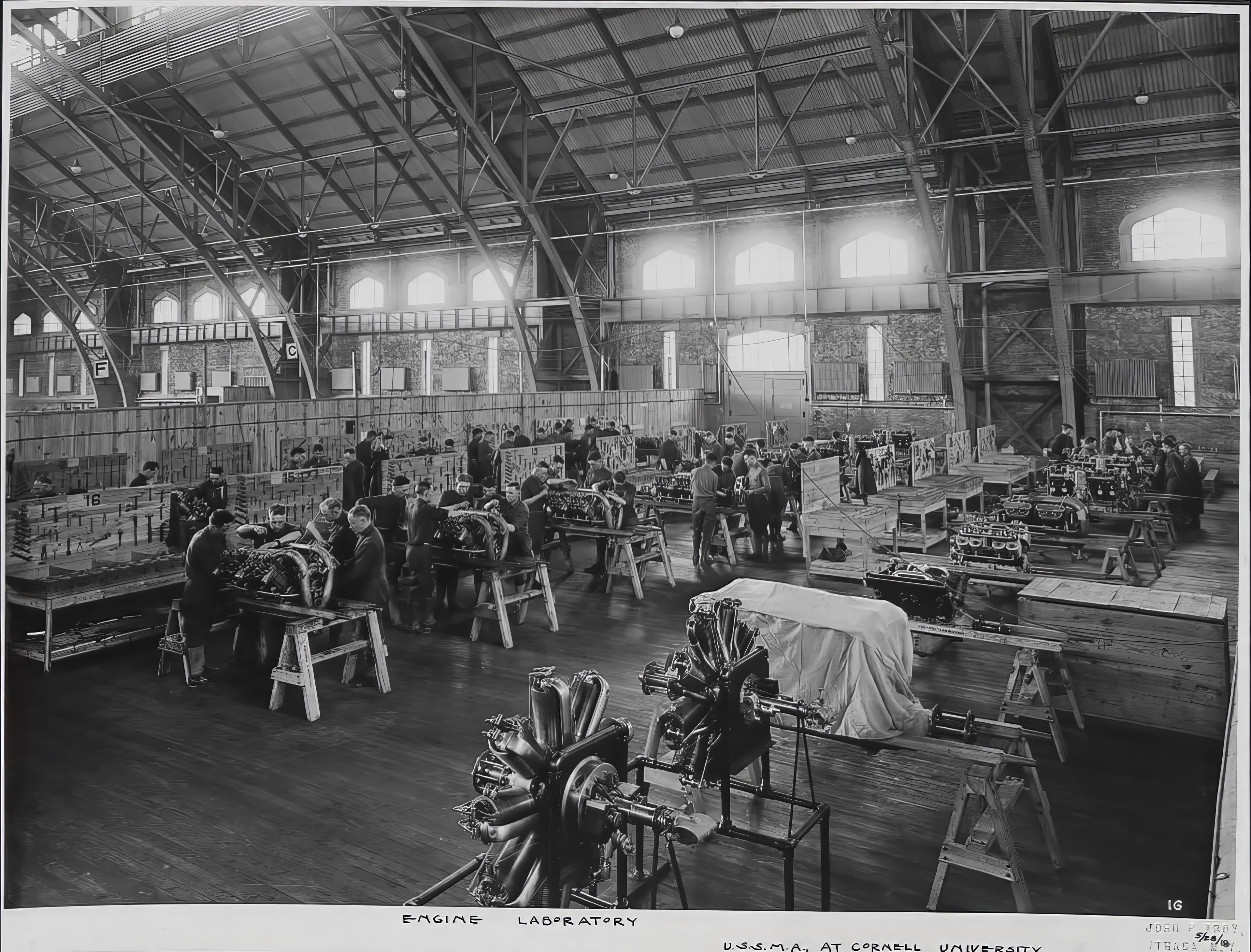 A 1918 photograph captioned Engine Laboratory, U.S.S.M.A. at Cornell University, showing rows of aircraft engines and trainees.