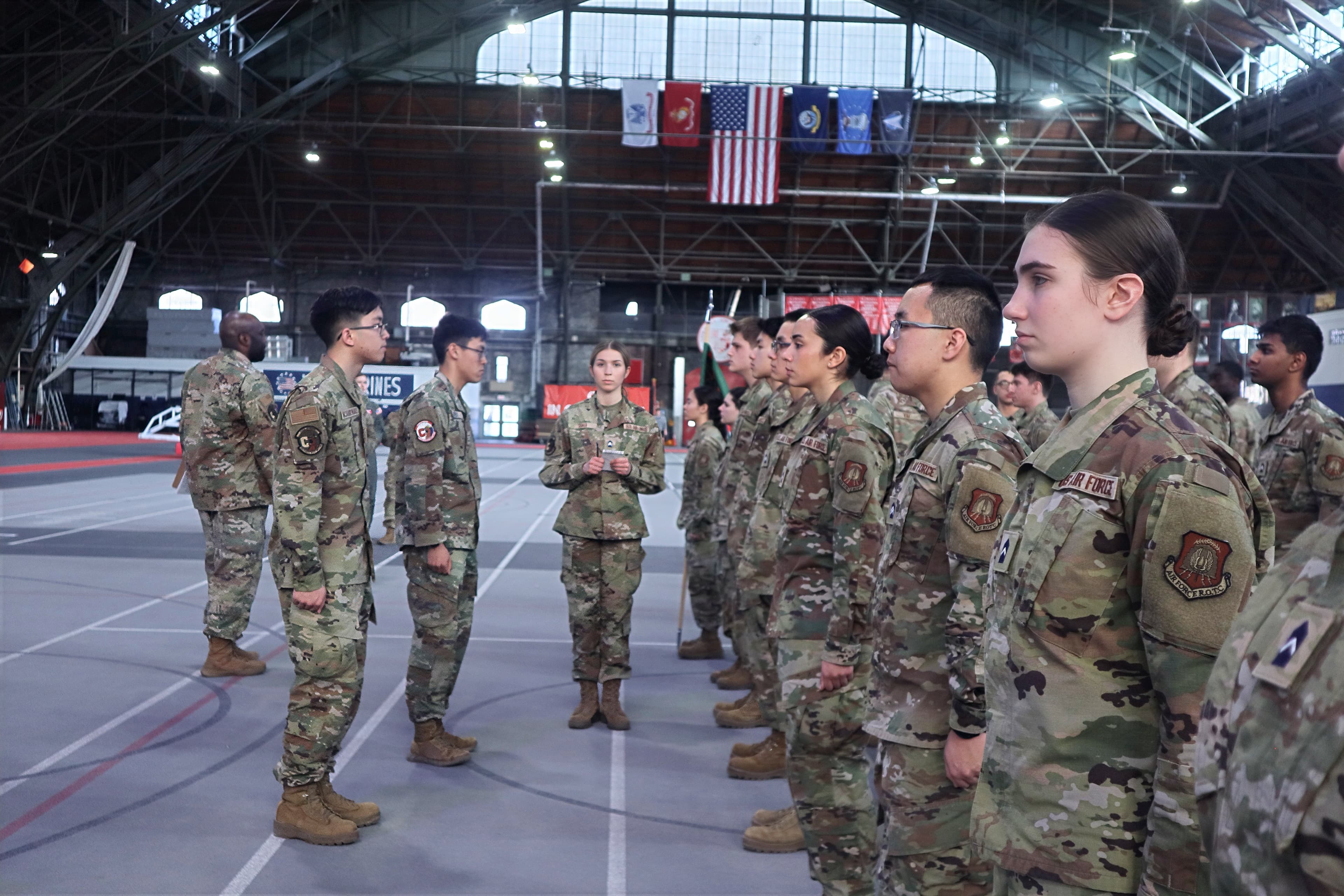 A line of cadets stands at attention during an inspection on the Barton Hall floor.