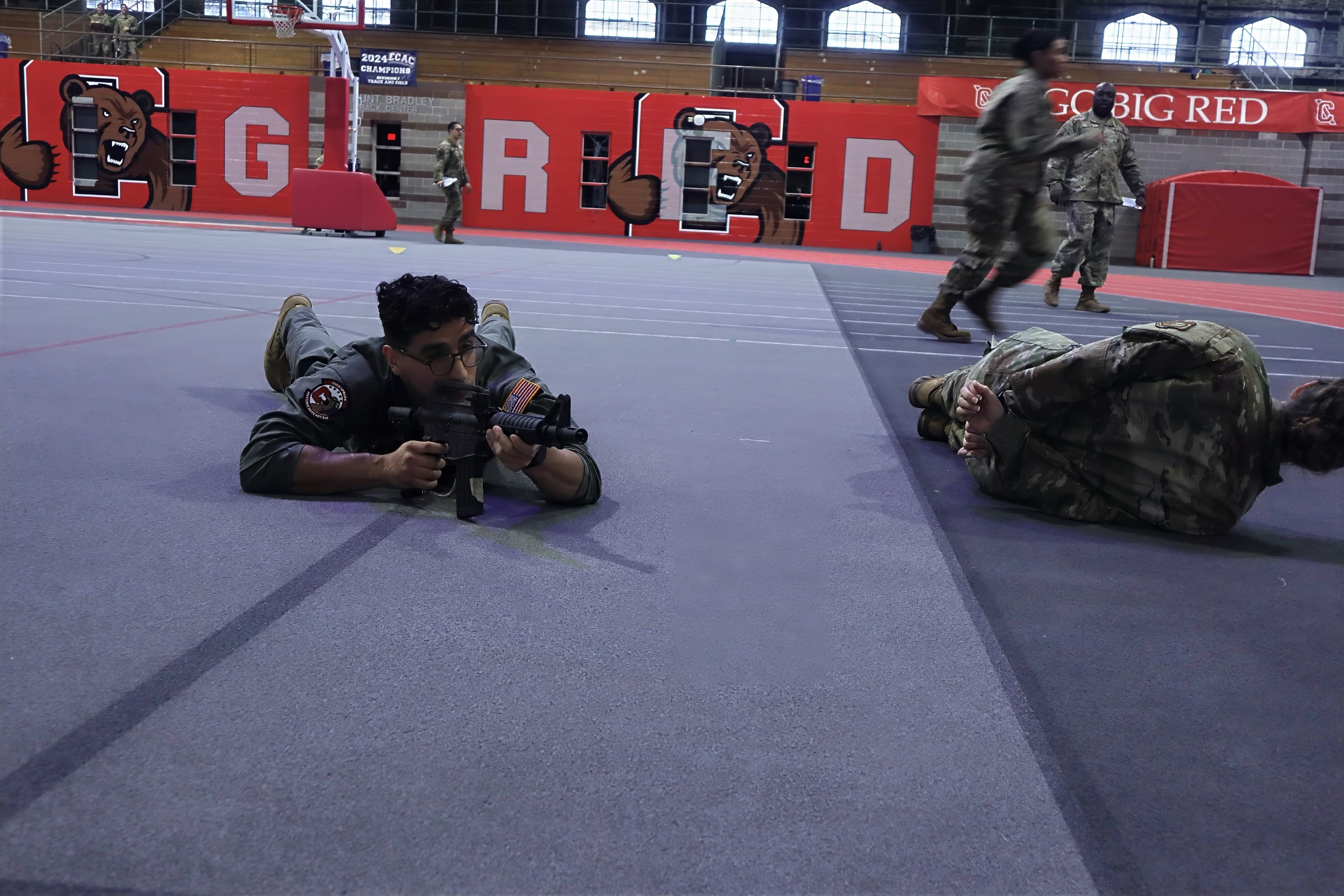 A cadet lies prone with a training rifle on the Barton Hall track during a tactics drill.