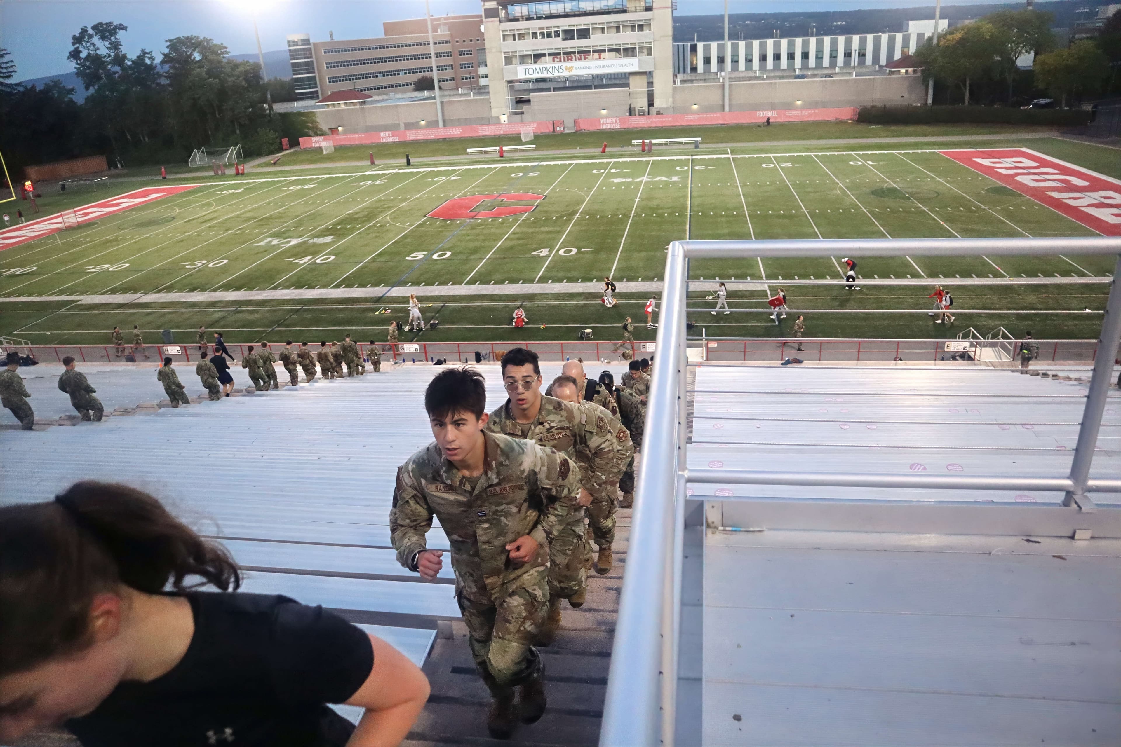 Cadets running up the stadium steps at Schoellkopf Field during an evening physical-training session.