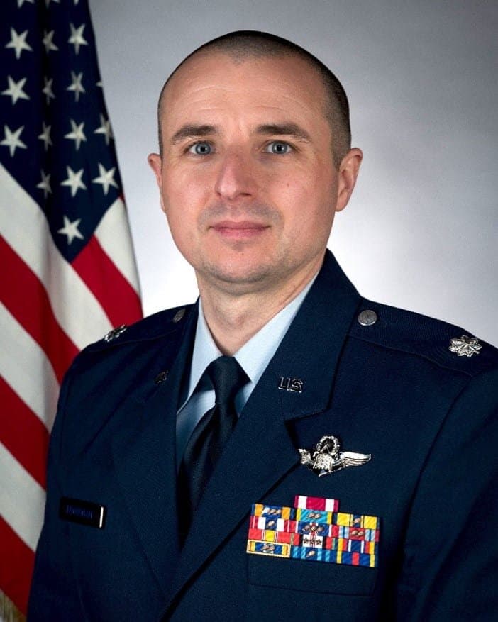 Official portrait of Lt. Col. Nicholas G. Brougham in service dress before the United States flag.